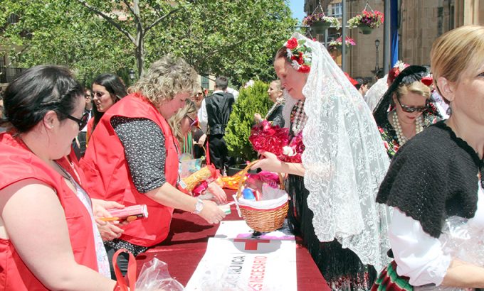 Voluntario de Cruz Roja recogen los alimentos y los productos de limpieza aportados por los participantes en la procesión.